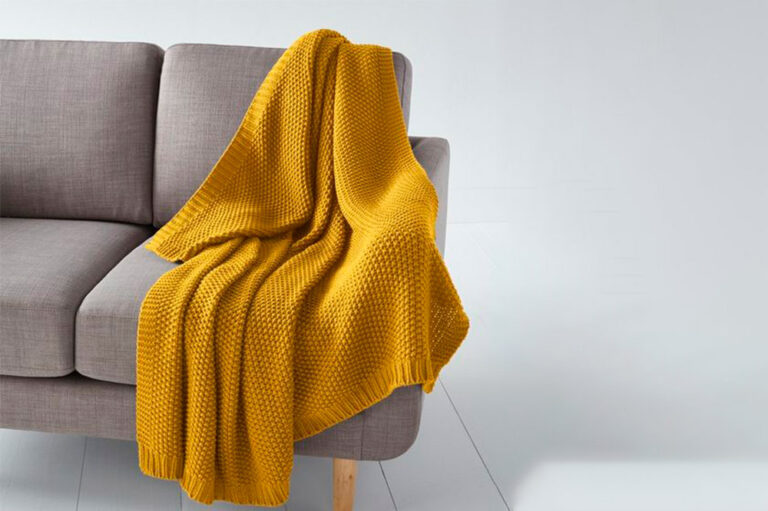 Sofa con una manta amarilla